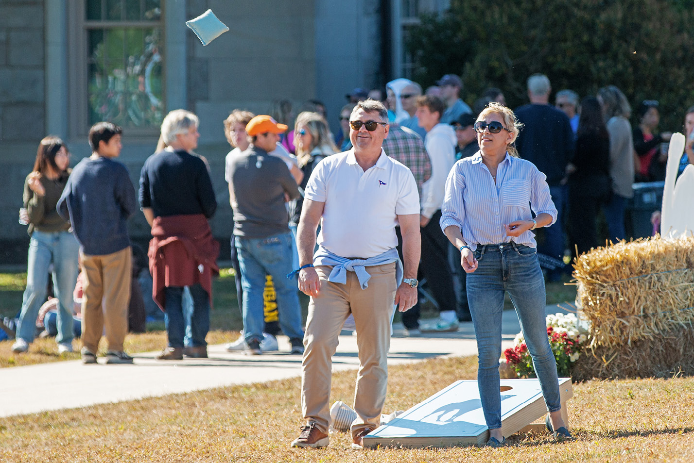 Parents playing cornhole at Fall Weekend