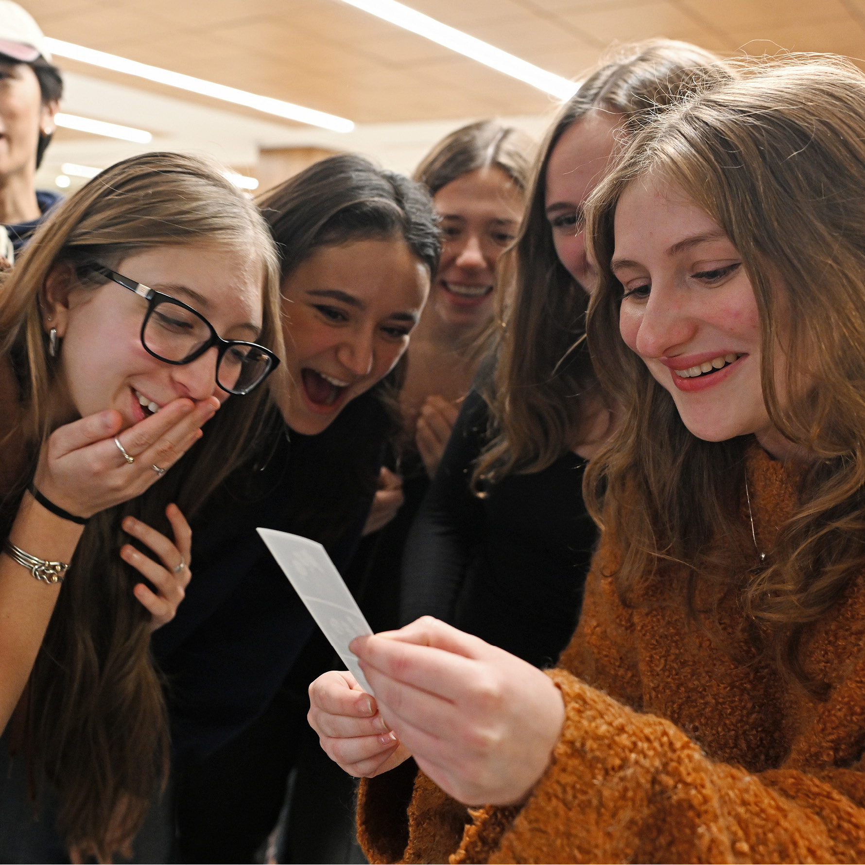 Laughing students look at photos taken in a photo booth