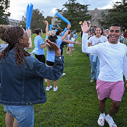 Student leaders high five new students as they take their 