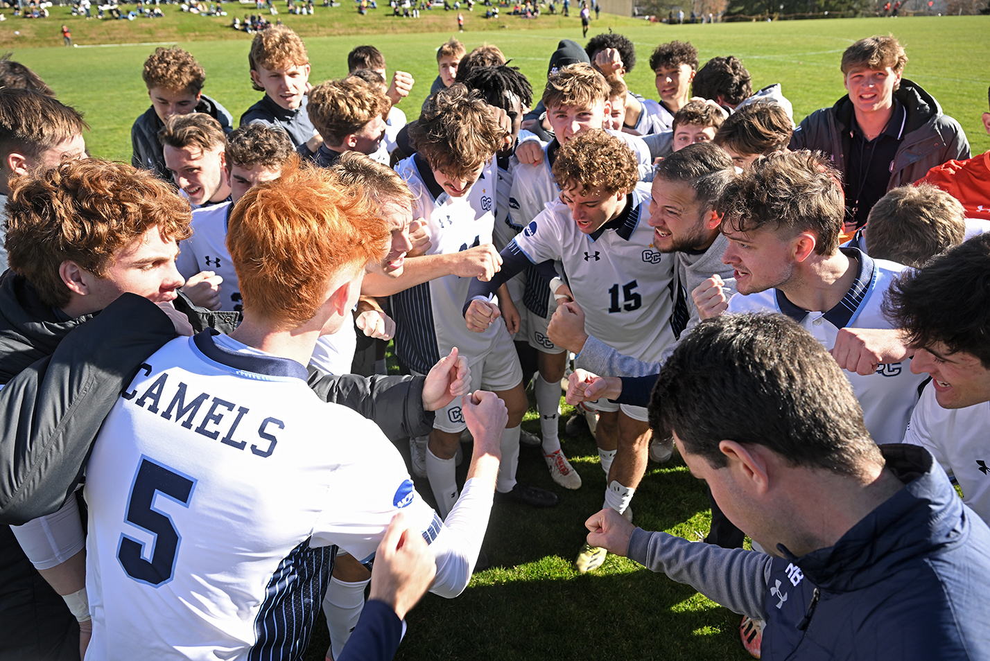 A soccer team gathers together for a pre-game cheer.