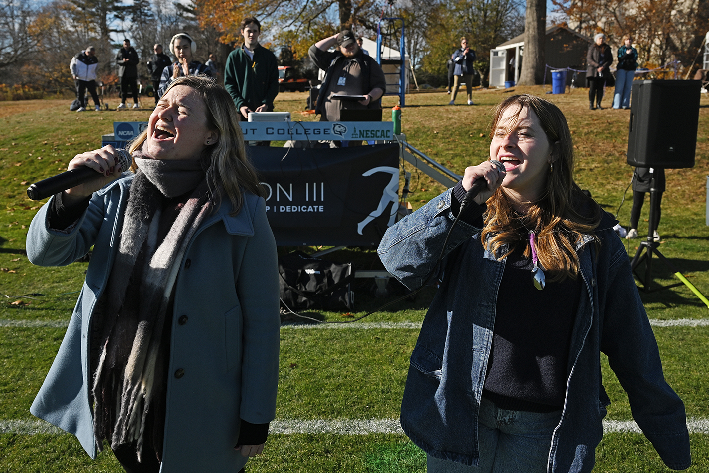 Two students sing the national anthem before a soccer match.