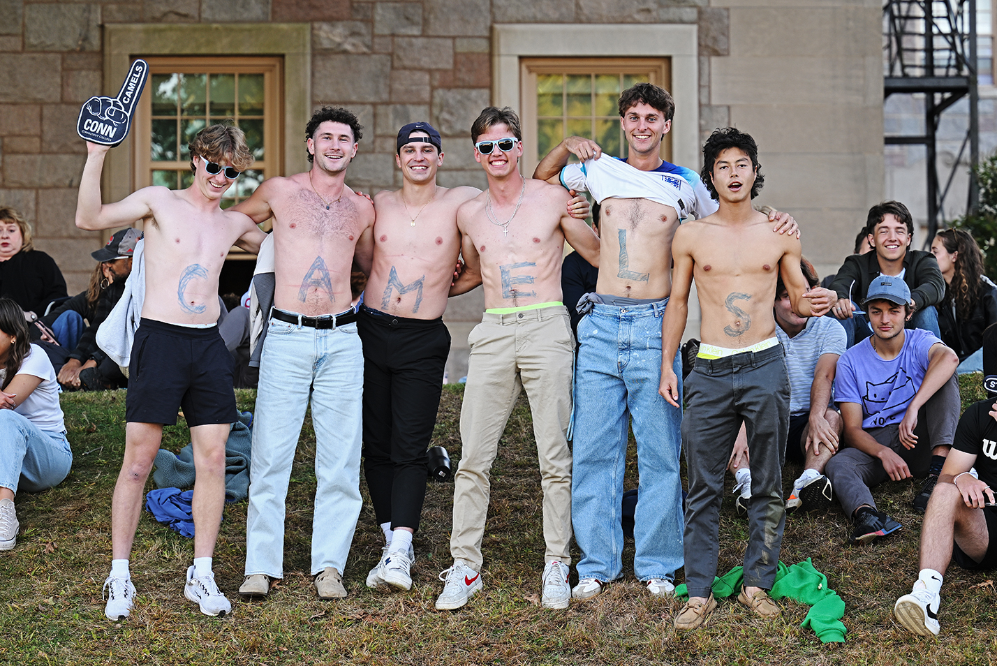 A group of students pose with the word CAMELS spelled out on their abdomens.