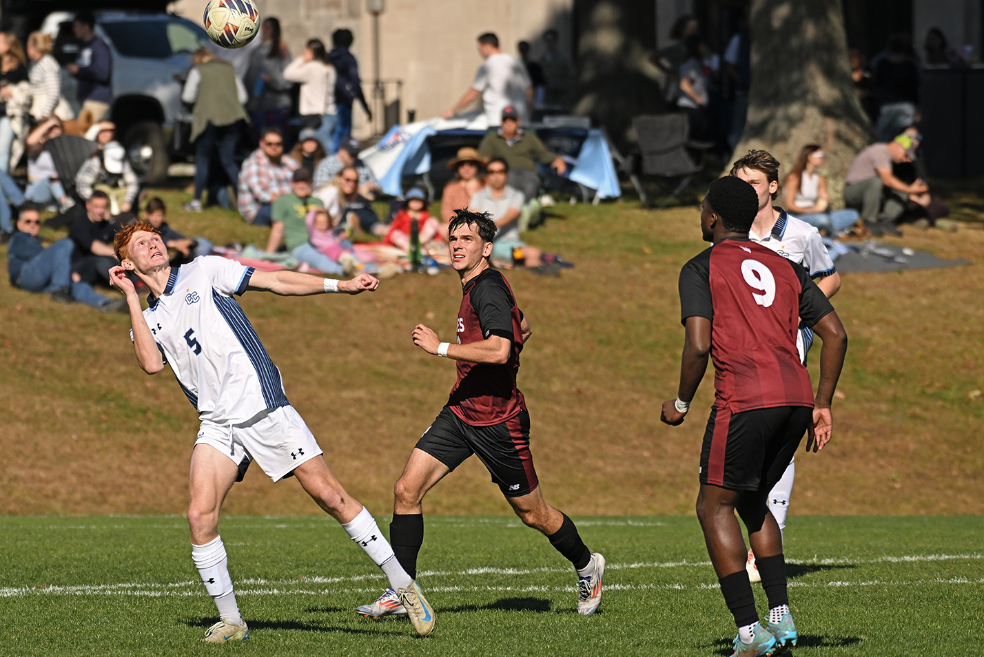 A soccer player heads the ball during a game.